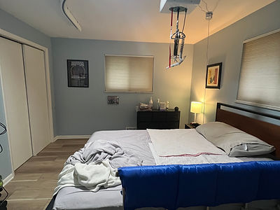 Ceiling track mobility transfer aid systems in a bedroom.