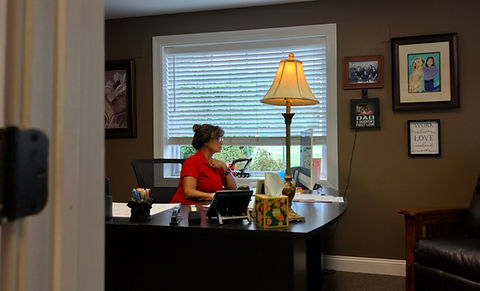 Woman in red shirt working at an office desk