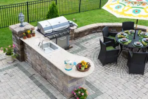 Outdoor kitchen and patio with built-in grill, showcasing site improvement expertise.