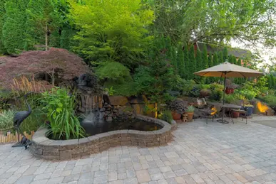 Landscaped backyard with pond and waterfall, showcasing site improvement.