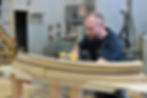 Craftsman shaping curved wood piece