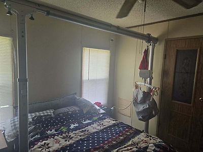 Overhead mobility transfer aid systems installed above a bed.