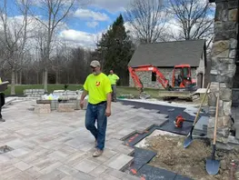 Workers laying pavers for site improvement