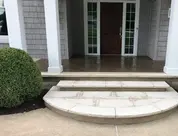 New stone steps and porch at house entrance.