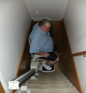 Man using a chair lift from local stairlift installation companies
