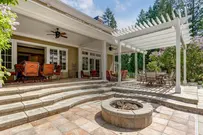 Patio with fire pit and pergola, showcasing site improvement expertise.