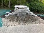 Rock waterfall feature with gravel, part of site improvement.