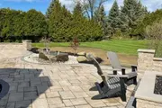 Paved patio with chairs and landscaped backyard