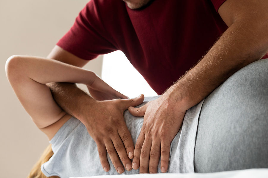 Therapist using Active Release Technique on patient's lower back muscles.