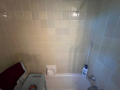 Old tiled bathtub area before walk in shower one day install