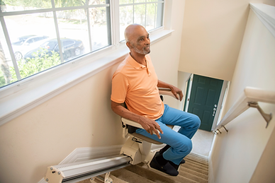 Senior man using a chair from local stairlift installation companies.