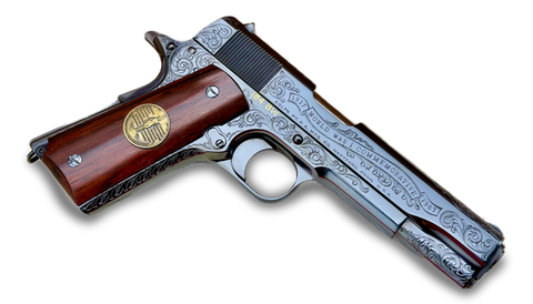 Engraved silver pistol with dark wooden grip and gold emblem.