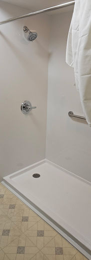 Accessible walk-in shower with grab bar for independent living.