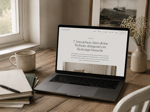 Moderner Laptop auf einem gemütlichen Holzschreibtisch mit geöffnetem Blogartikel über die Anzeichen, dass eine Website ein Redesign benötigt.