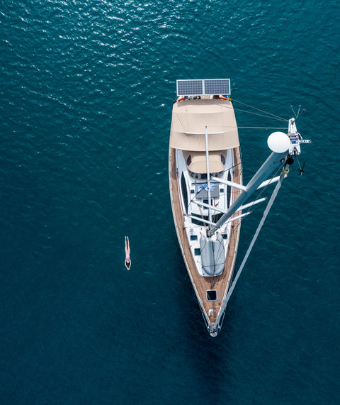 Sailing boat sun oddysey with girl swimming