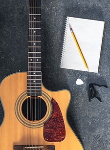 acoustic-guitar-notebook-black-textured-background-top-view.jpg