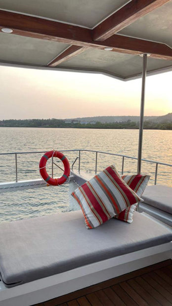 Plush seating onboard a Luxury catamaran in Goa with red and white pillows