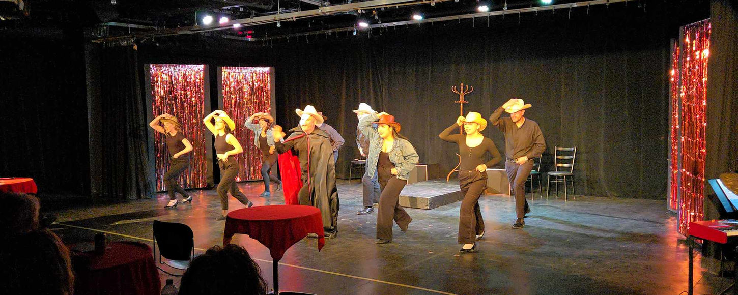 Dancing group with cowboy hats on stage during evening performance. What's On Stage