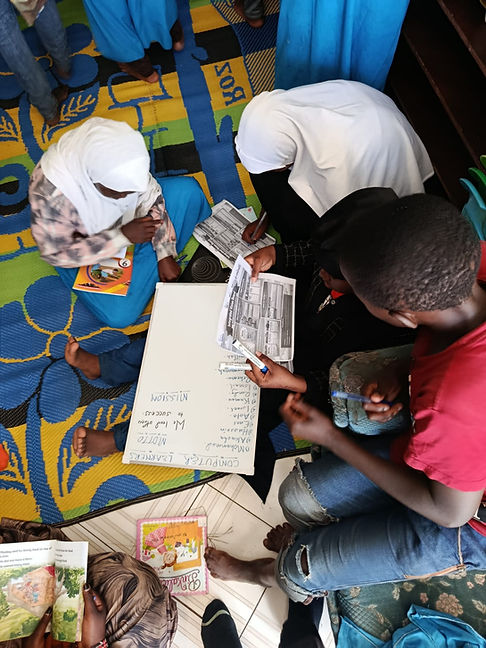 Three children studying on floor with books