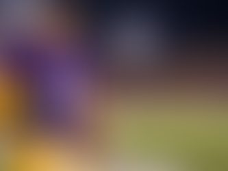 Anonymous LSU-style backup quarterback wearing number 11 stands ready on the sideline with helmet and football