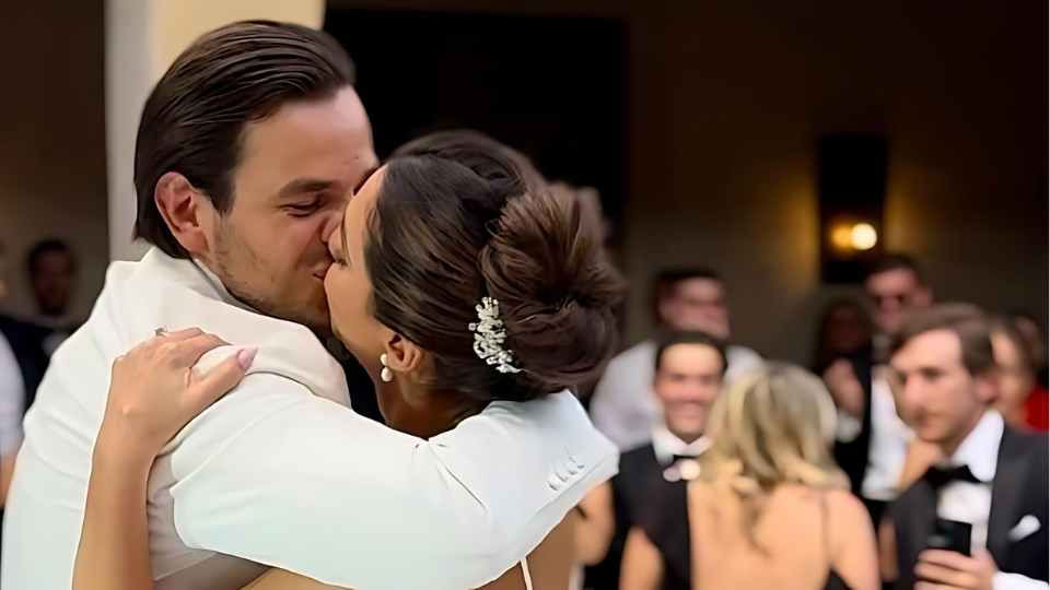 Alan and Joana Molina share a joyful kiss during their grand entrance at Casa Adela in San Miguel de Allende, surrounded by friends and family celebrating their wedding.