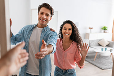 Happy couple welcoming you into their Lavallette real estate home