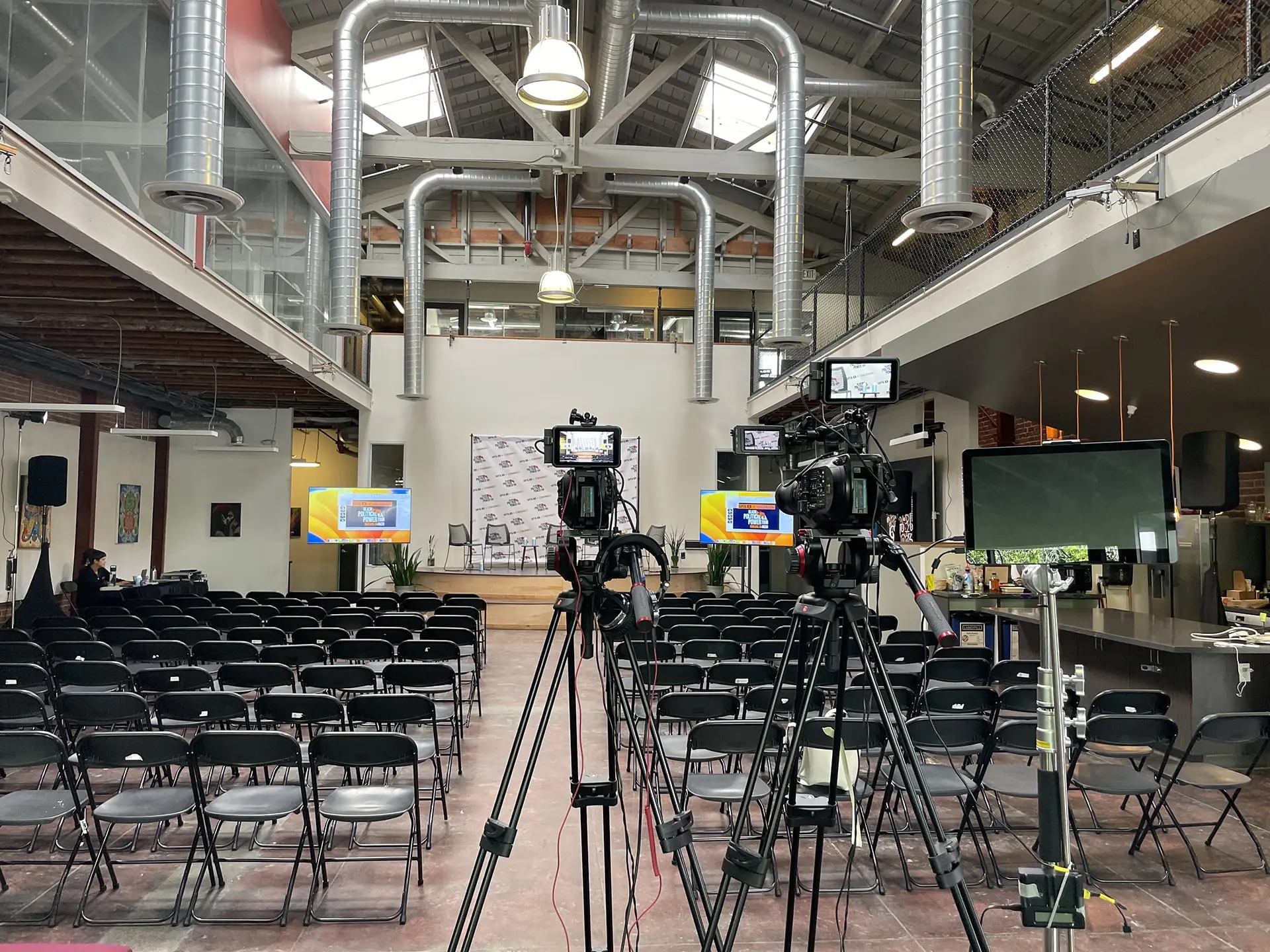 Multi-camera setup positioned for the Black Political Power Tour – Oakland at Oakstop, with an empty audience space and branded stage backdrop in an industrial-style venue.