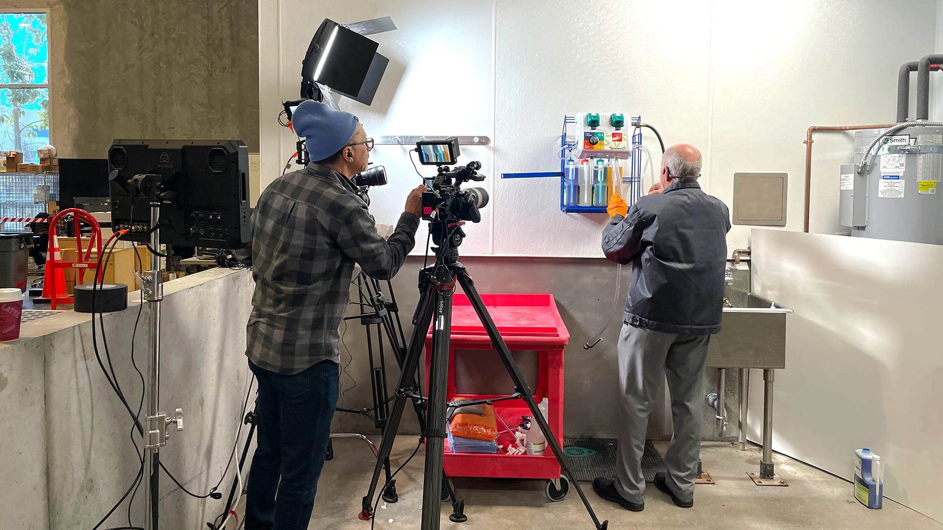 Bidar Video crew filming a step-by-step Skilcraft dilution system training video with lighting, camera, and audio setup in a utility workspace.