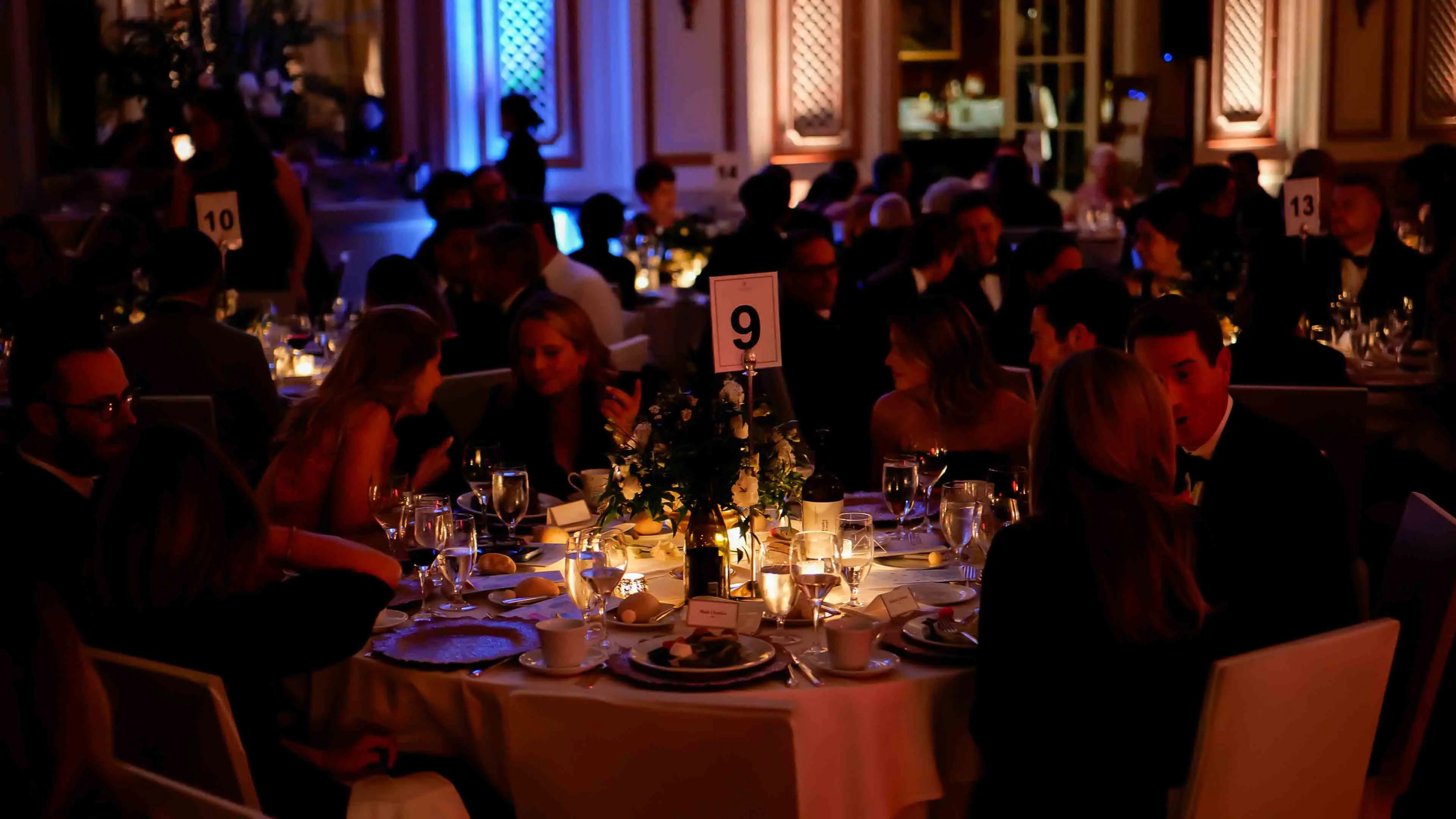 Guests seated at candlelit dinner tables with elegant place settings and floral centerpieces during the GREAT GBx Gala 2024 at the Palace Hotel in San Francisco.