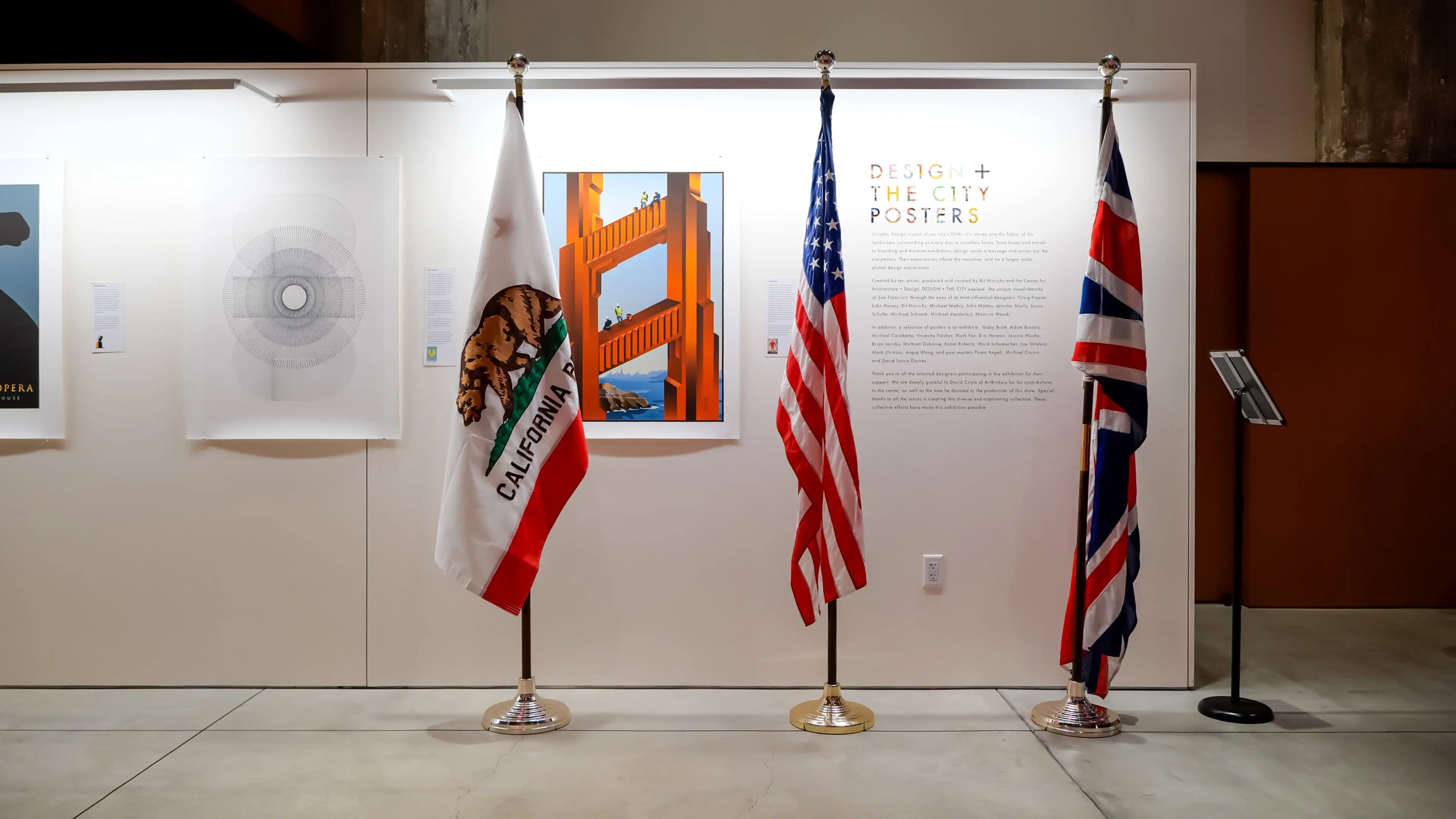 alifornia, United States, and United Kingdom flags displayed in front of a “Design + The City Posters” exhibit wall at the Center for Architecture + Design in San Francisco.