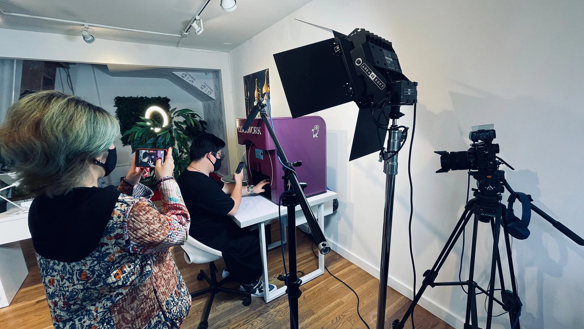 Behind the scenes of a Clockwork robot nail polish tutorial, with camera, lighting, and users demonstrating the machine during filming.