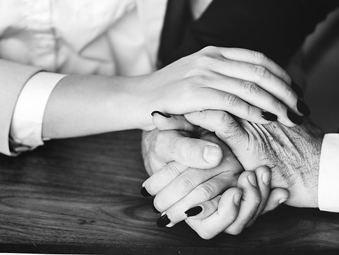 Black and white photo of two people holding hands