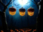 Set of 3 acorn LED tea light lanterns hanging against a dark night sky..