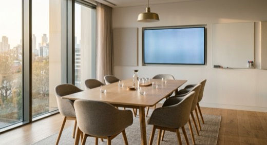 A meeting room set and ready with a display screen and whiteboard. Fuse Workspace meeting rooms are bookable by the hour at four Austin locations.