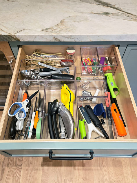 Kitchen drawer with neatly organized utensils, scissors, and kitchen tools in clear dividers, styled by a professional home organizer for easy access and efficiency.