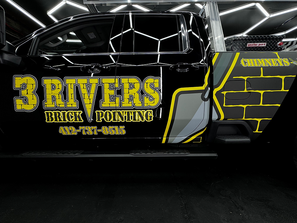 Black vehicle with "3 Rivers Brick Pointing" text in yellow and contact number. Brick pattern and trowel graphic on the side. Indoor setting.