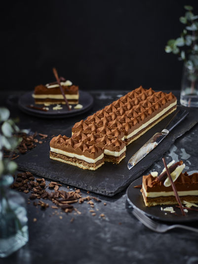 Chocolate cream rectuangluar cake on dark grey background