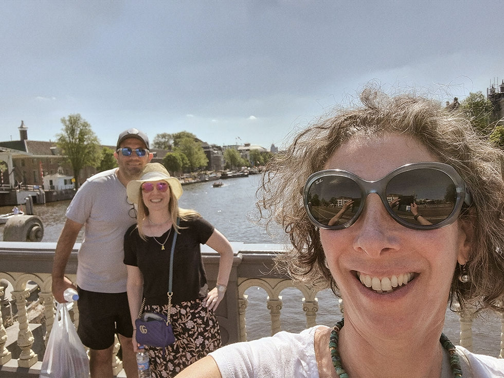 A selfie taken by Inbal Tur-Shalom while guiding a tourist couple in Amsterdam, with the Amstel River in the background.