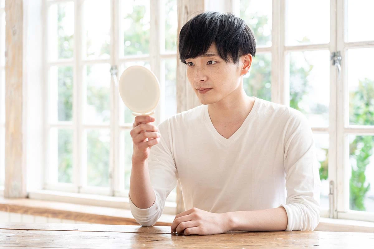 鏡を見る男性