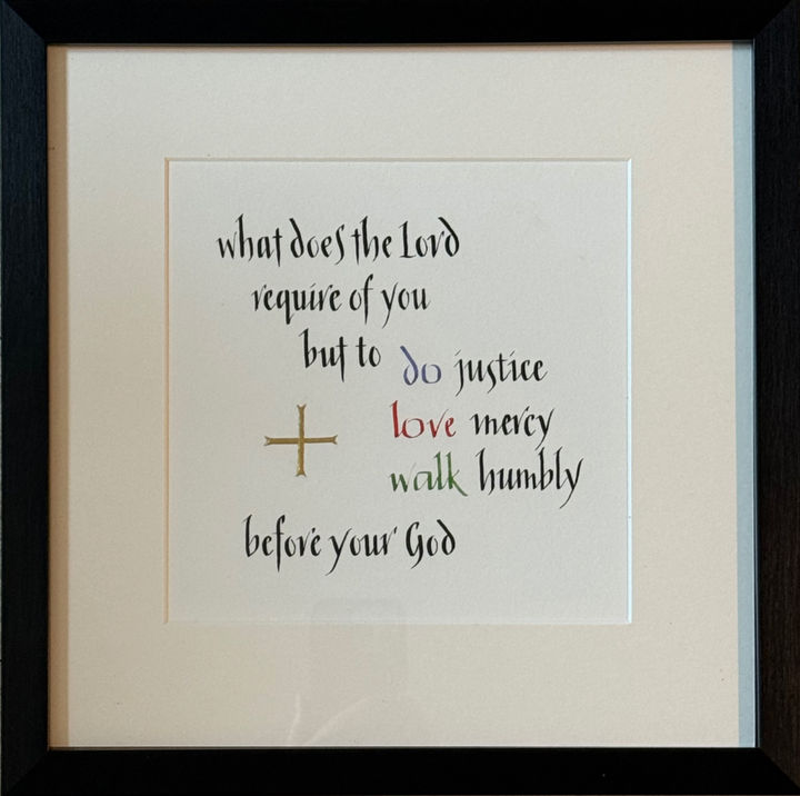 Black lettering of Micah 6.8 with coloured highlight words and gold cross