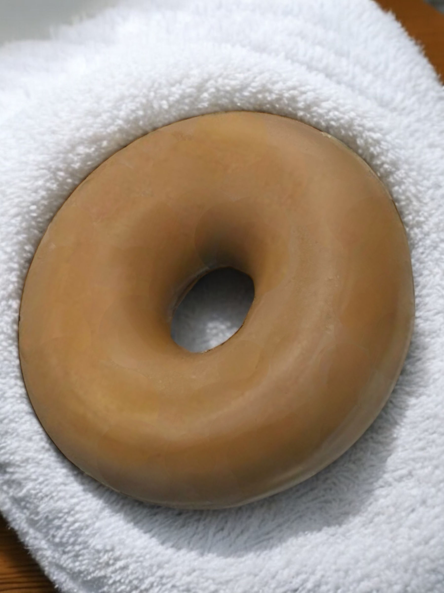 Large glazed donut on white towel