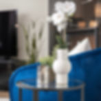 Salon fauteuil d’appoint velours bleu royal coussin beige en lin orchidée bougie table en