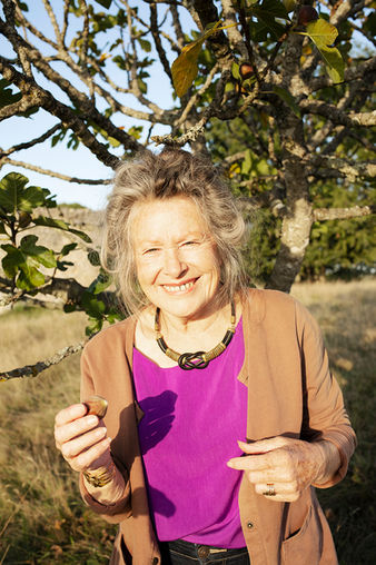 Photographie de reportage, lifestyle pour le livre Paysage comestibles, ecrit par Evaine Merle, aux editions Ulmer. Portrait d'une femme mangeant une figue pres de l'arbre fruitier, en dordogne. 
