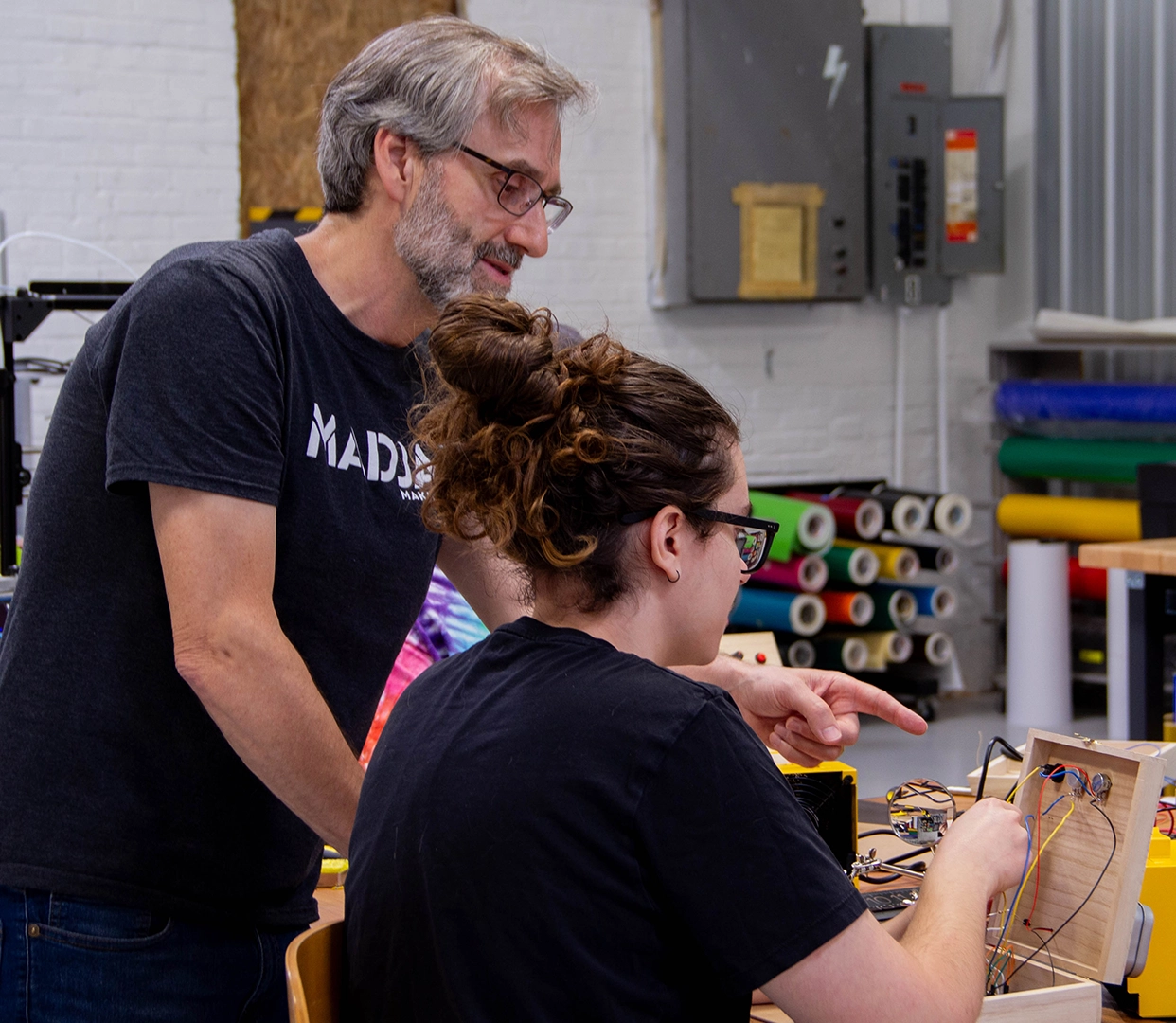 Maker in Residence Michael Pounds helps a student solder electronics to create a synthesizer