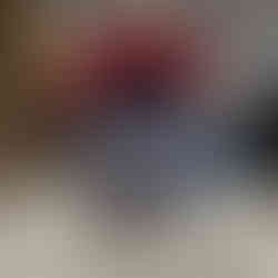 Kevin The Quest Charging Alien, holds an AA battery in his battery dispensing mouth.