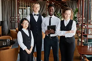 group-portrait-restaurant-staff-with-servers-wearing-classic-black-white-uniforms-smiling-