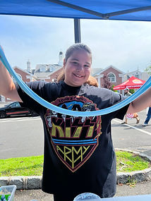 A girl stretching freshly made blue slime at a vendor event