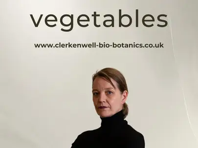 Dr Angela Haas wearing a black turtleneck standing in front of a white background.