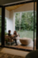 Hillside House owners sitting outside in front of a fire, talking and smiling.