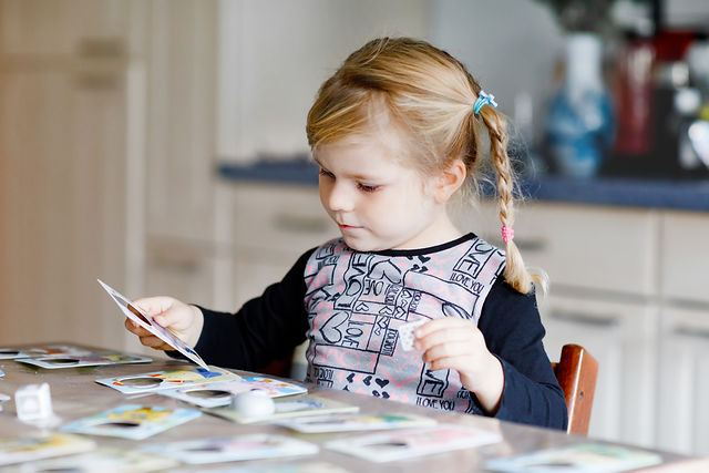 Adorable cute toddler girl playing picture card game. Happy healthy child training memory,